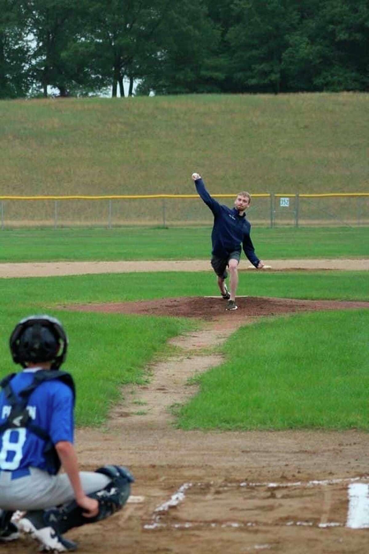 Jeff Stewart's son Iain throws out the first pitch at Manistee's weekend youth baseball tournament on Friday. (Courtesy photo)