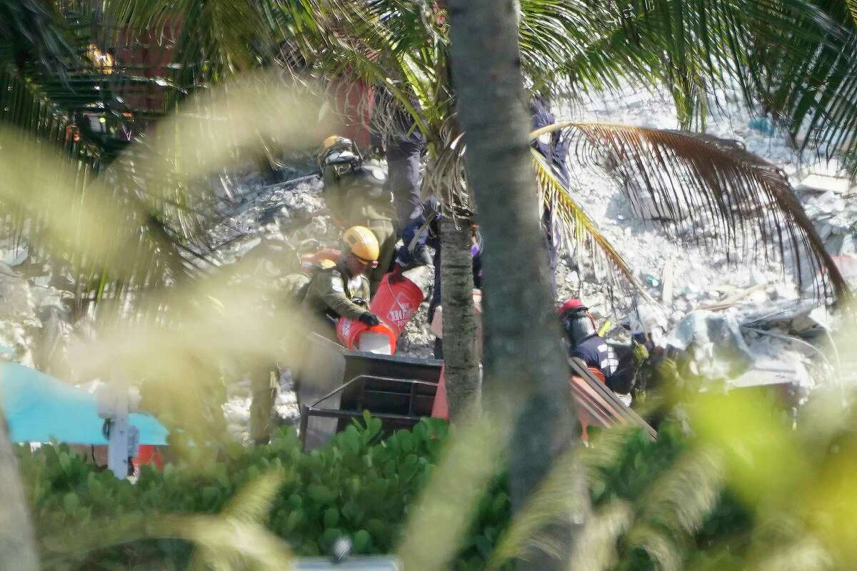 Rescue workers are seen on the site of the Champlain Towers South condo tower, Sunday, June 27, 2021.