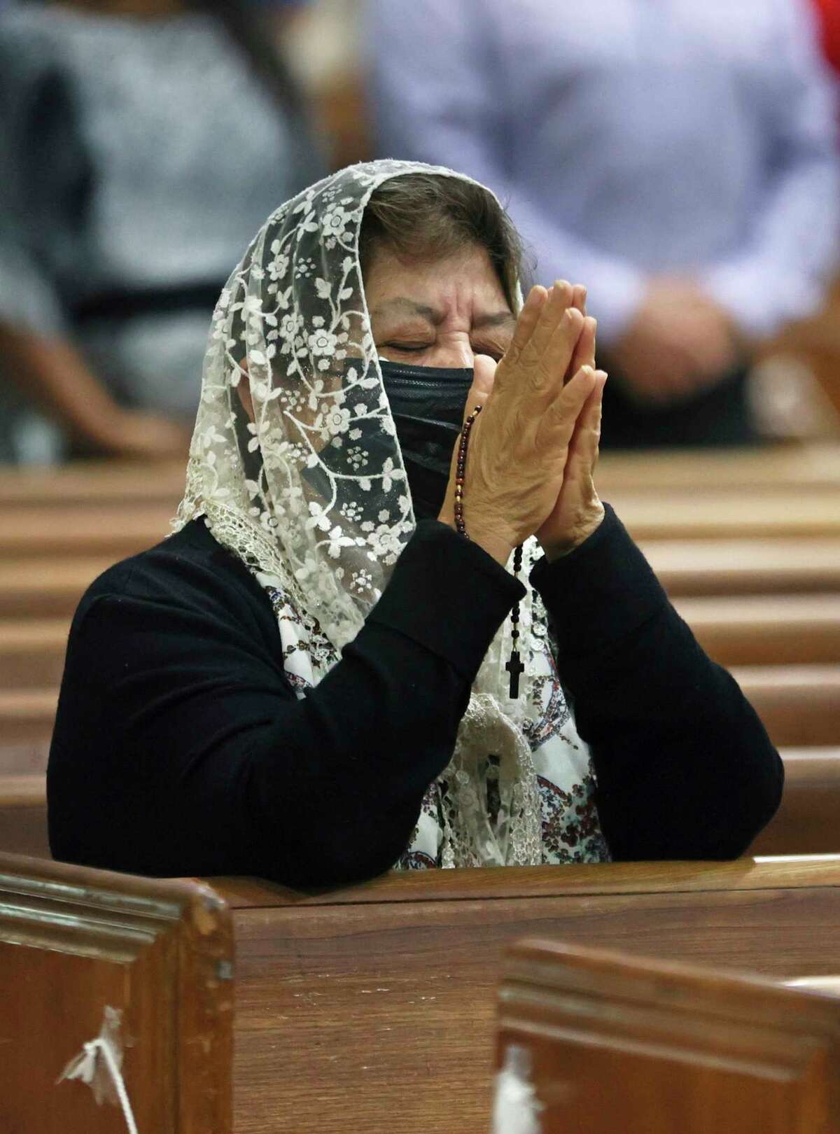 Sonia Rivas prays during Sunday mass at St. Joseph's Catholic Church in Miami Beach, Fla, early Sunday, June 27, 2021. The feeling in the church, just a few blocks from where rescuers continued to dig for survivors through the rubble of a partially collapsed building at Champlain Towers South, was solemn, with people filtering in and out for the early masses. (David Santiago/Miami Herald via AP)