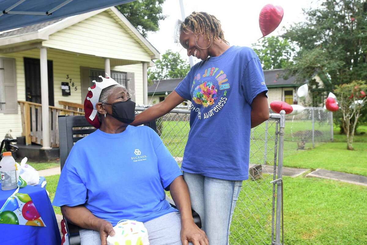 Diverna Abatte gets a hug and visit from Toni Hayes, one of her foster children, during a drive-by parade and celebration at her home to honor her 42 years serving as a foster parent. Abatte fostered with Buckner since 2002, but began her lifelong ministry of fostering with Jefferson County's Child Protective Services in 1979. In all, roughly 175 children have crossed her doorstep throughout the years, many. of which she has kept up with over the years. Photo made Wednesday, June 23, 2021 Kim Brent/The Enterprise