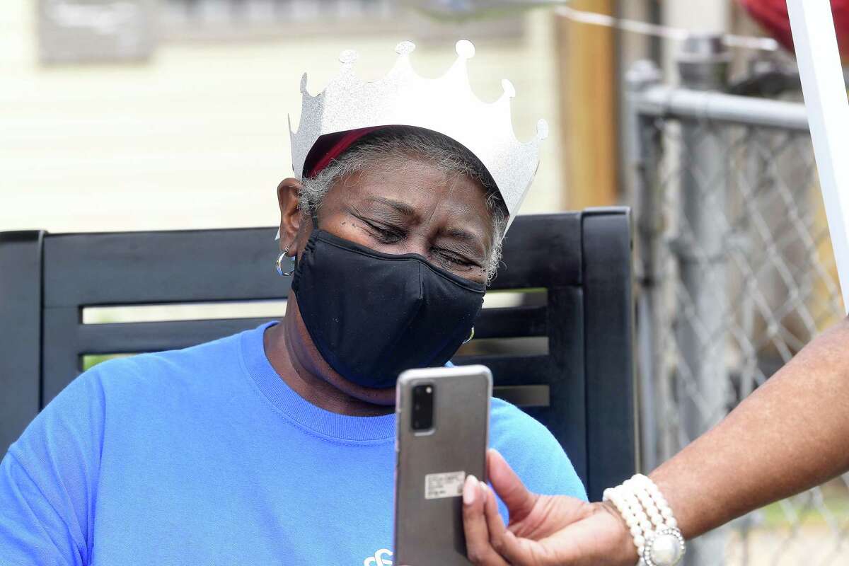 Diverna Abatte takes a call from a well-wisher during a drive-by parade and celebration at her home to honor her 42 years serving as a foster parent. Abatte fostered with Buckner since 2002, but began her lifelong ministry of fostering with Jefferson County's Child Protective Services in 1979. In all, roughly 175 children have crossed her doorstep throughout the years, many. of which she has kept up with over the years. Photo made Wednesday, June 23, 2021 Kim Brent/The Enterprise