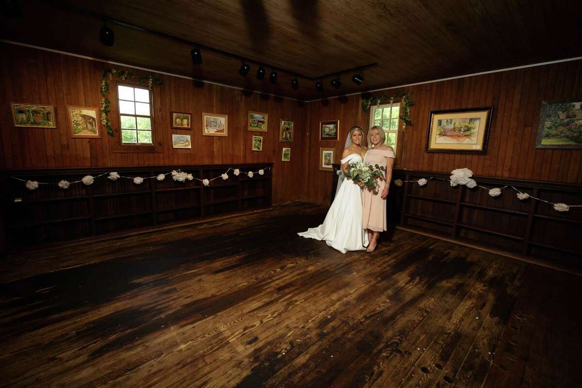 Tara-Marie Lynch and her mother, Judi, stand in the Cass Gilbert Carriage Barn at Keeler Tavern Museum in Ridgefield, where Judi's paintings were put on display for her daughter's wedding day.