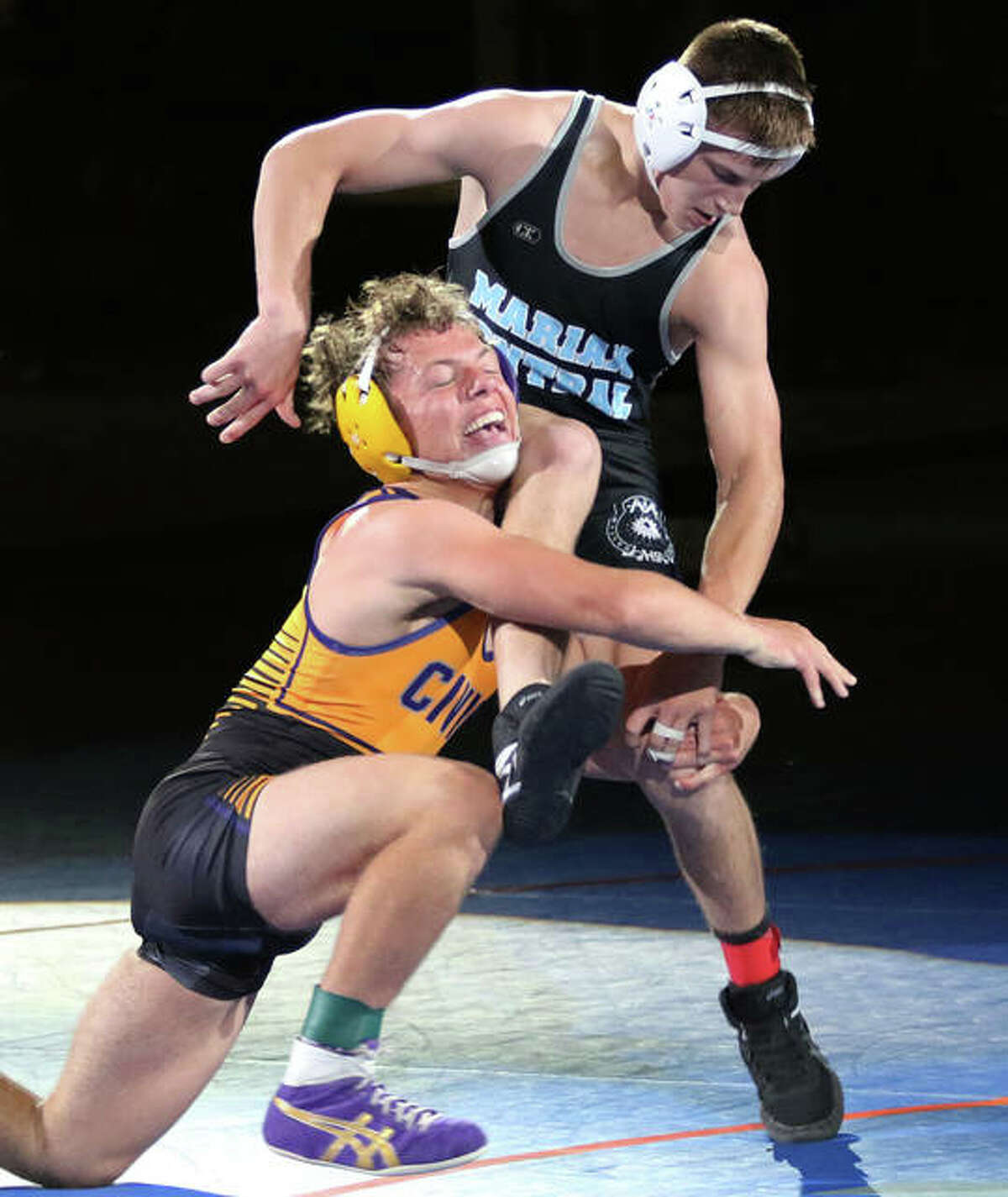 CM’s Caleb Tyus (left) shoots in for a takedown against Woodstock Marian Central Catholic’s Chris Moore late in Tyus’ 7-2 win in the 138-pound title match Friday in the IWCOA Class 2A state meet in Springfield.