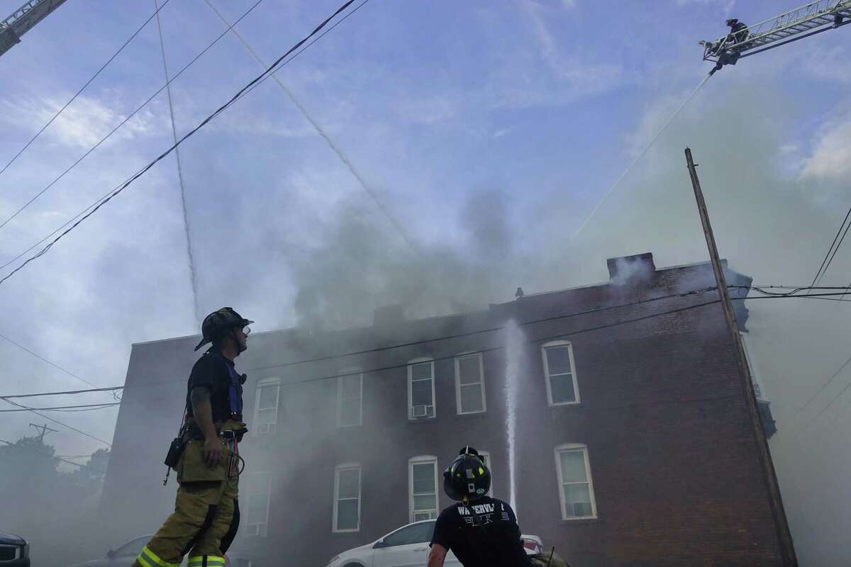 Firefighters battle a fire in three row houses near the intersection of 24th Street and Broadway on Monday, June 28, 2021, in Watervliet, N.Y. The fire tore through three row houses. (Paul Buckowski/Times Union)