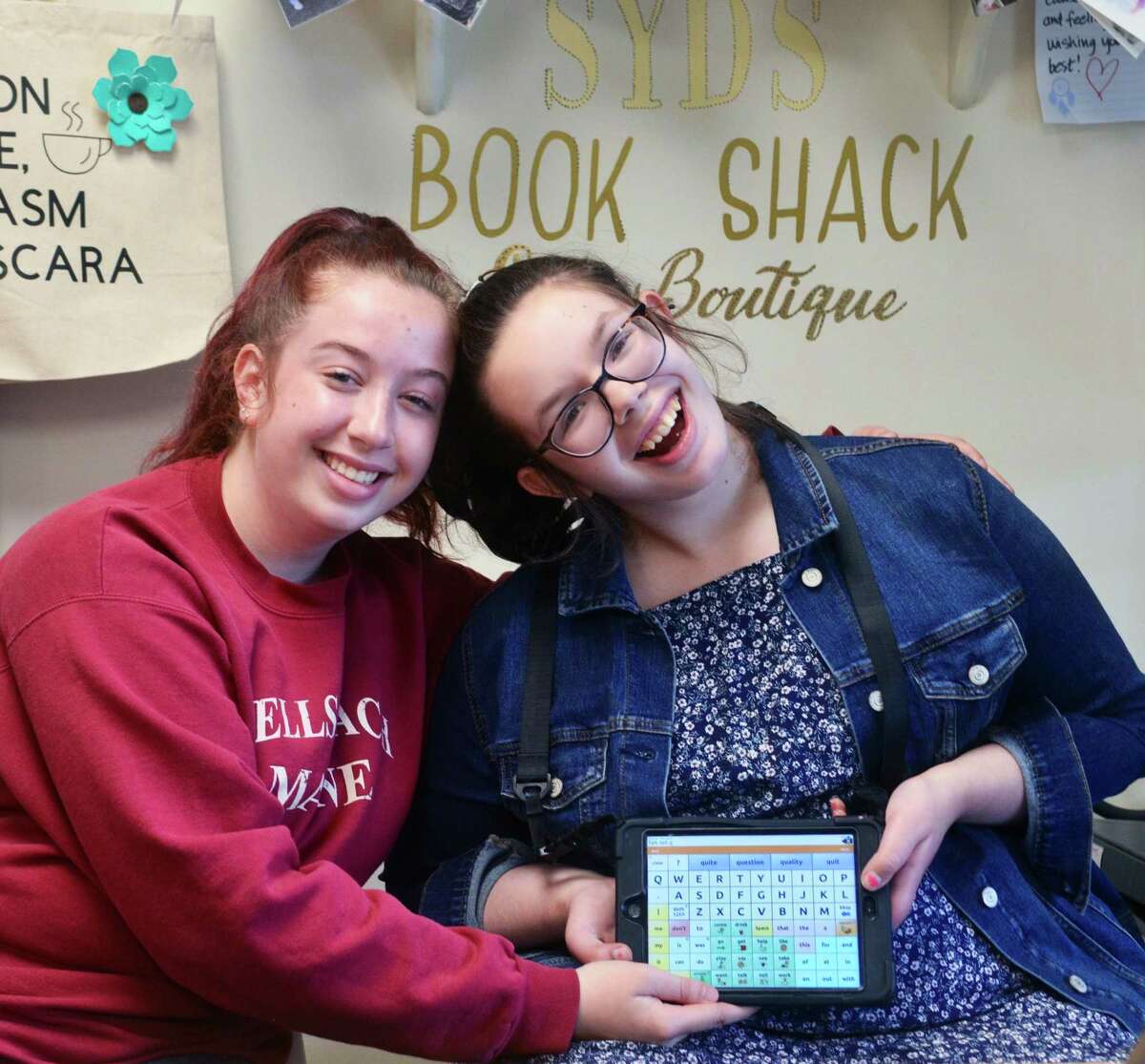 Syd Daggett, a 16-year-old who is on the autism spectrum and is nonverbal, right, with her twin sister, twin sister, Maddie, who volunteers at the bookstore.