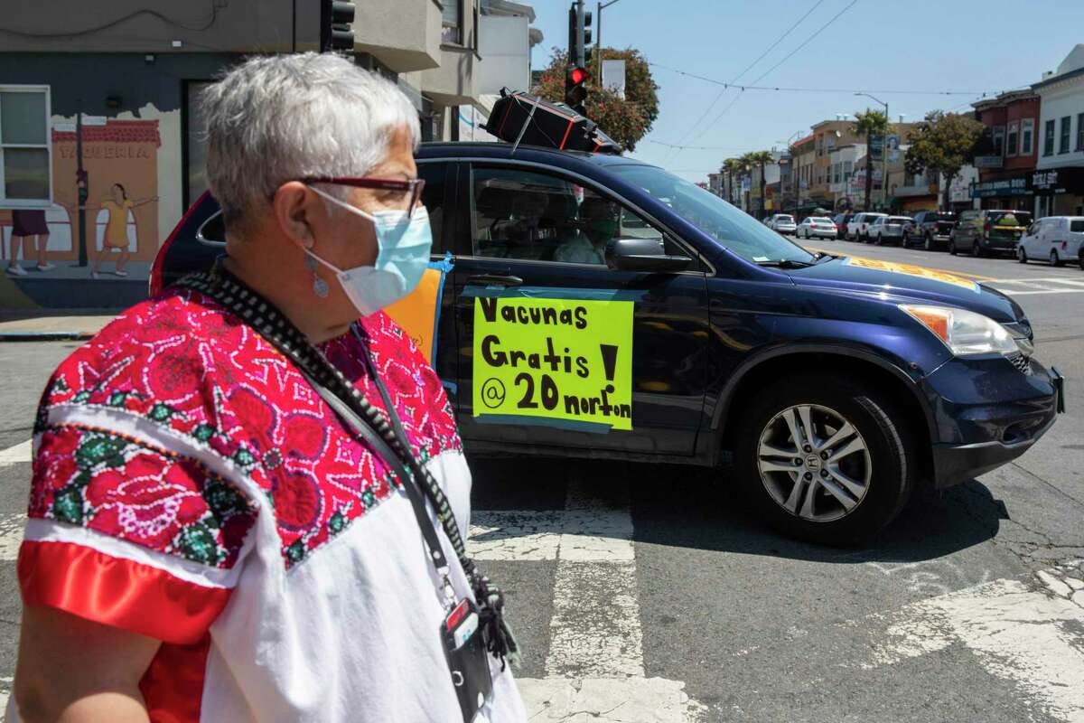 Neighborhood vaccine lead Bertha Hernandez’s husband drives the mobile vaccine outreach car down Mission Street from a community pop-up vaccine site in partnership with San Francisco’s Department of Public Health and UCSF in the Excelsior district of San Francisco on June 18, 2021.