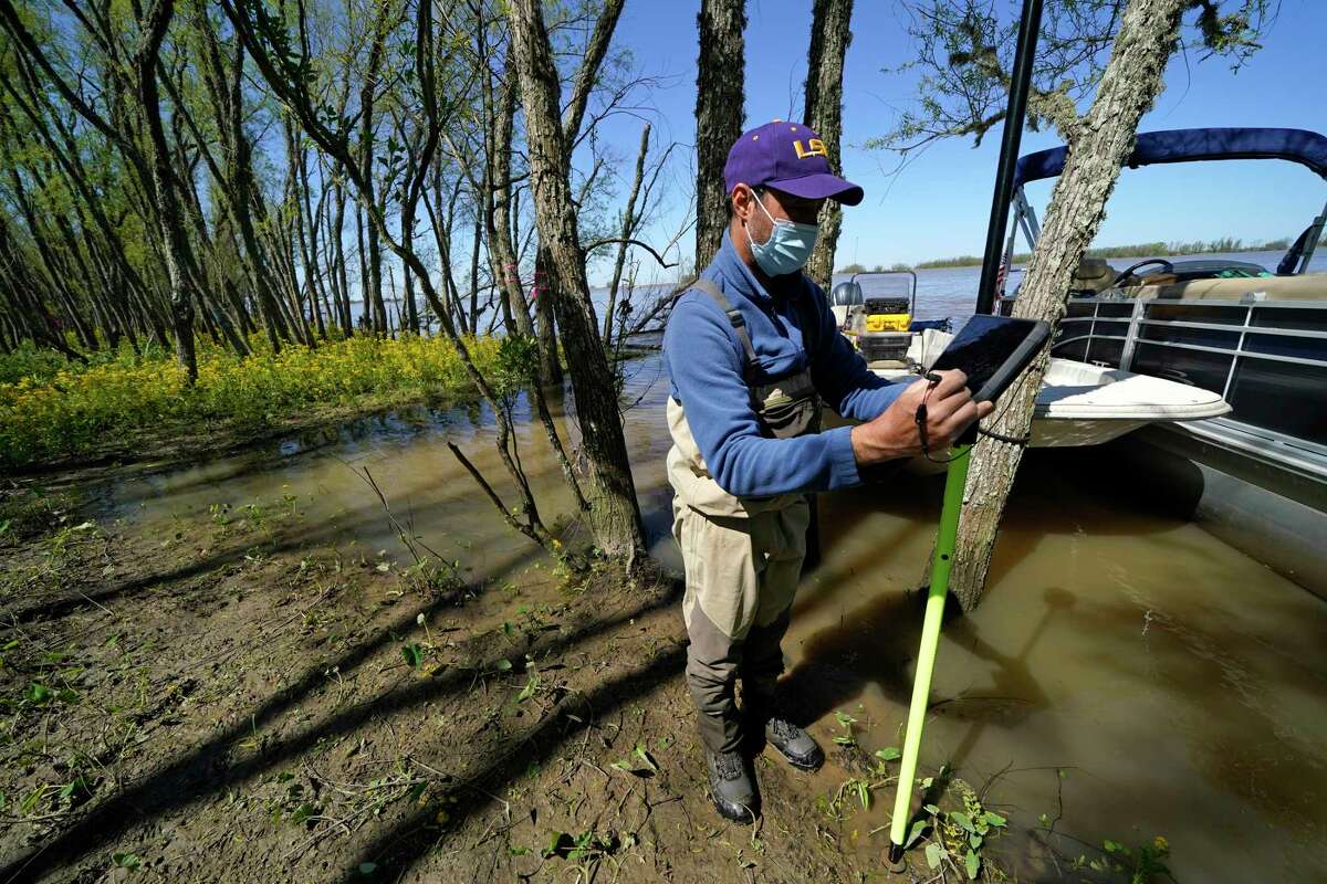 Andre Rabay, research scientist for the LSU Department of Oceanography and Coastal Science uses a real time kinetic (RTK) GPS to take measurements on Mike Island, part of the Wax Lake Delta in the Atchafalaya Basin, in St. Mary Parish, La., Friday, April 2, 2021. NASA is using high-tech airborne systems along with boats and mud-slogging work on islands for a $15 million study of these two parts of Louisiana's river delta system.