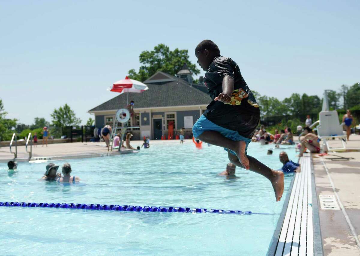 Greenwich's Noah Bates, 8, jumps in the water at the Greenwich Pool in Byram Park in Greenwich, Conn. Tuesday, June 29, 2021. Folks flocked to the pool as temperatures soared into the 90s Tuesday with more hot weather in the mid-90s expected Wednesday.
