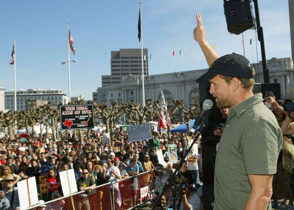 Woody Harrelson Actor Woody Harrelson has made many of his sociopolitical views known to the public, including his support for marijuana legalization and environmental protection. At a 1996 protest, Harrelson and several other protesters scaled the Golden Gate Bridge to hang up a sign criticizing Maxxam Inc. CEO Charles Hurwitz. The outspoken activist and vegan narrated the 2020 documentary 
