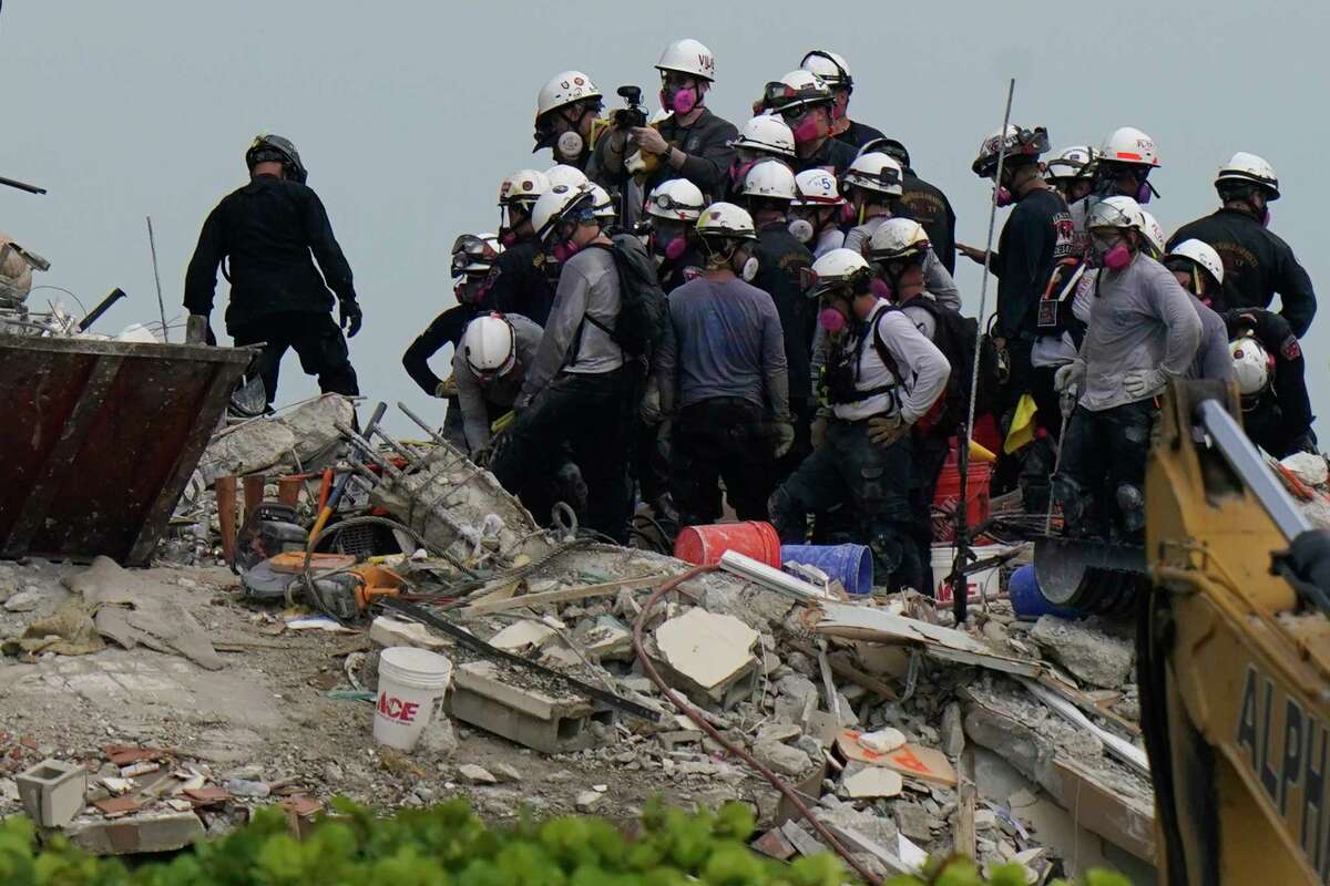 Search and rescue personnel work atop the rubble at the Champlain Towers South condo building, where scores of people remain missing almost a week after it partially collapsed, Wednesday, June 30, 2021, in Surfside, Fla.