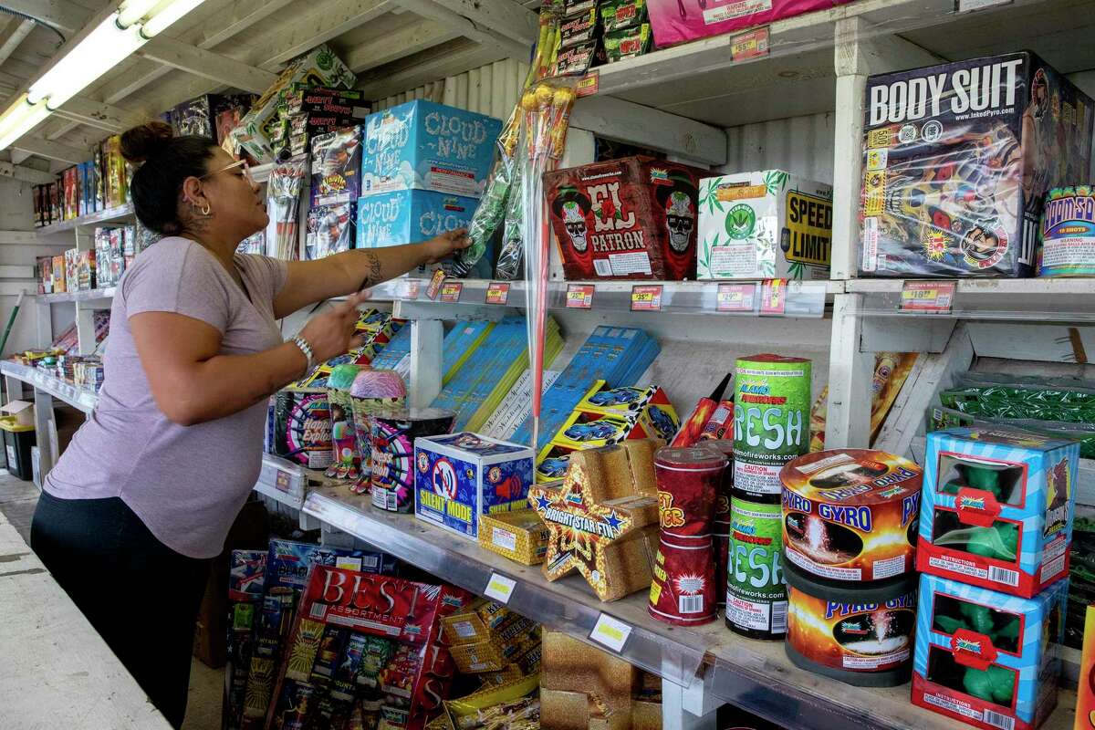 Neiva Garcia goes through her inventory of fireworks at the Alamo Fireworks stand she operates with her cousin, Crystal Casanova, on Walzem Road.
