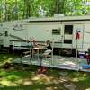 Gordie Huckins left, and wife Carrie, who opened Northern Sites Campground on the River, spend time at their own campsite. The pair are addicted to the outdoors and enjoy camping in all seasons. (Photo by Tereasa Nims)