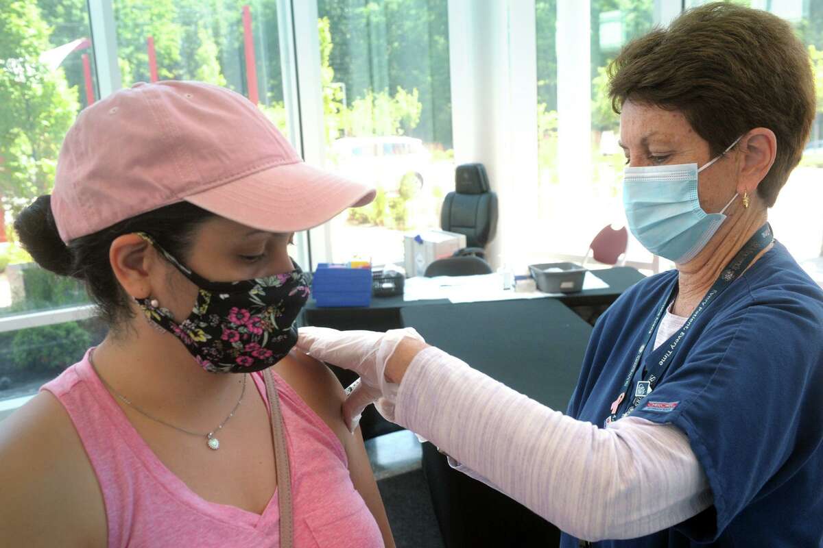 Wilza Cordero, of Ansonia, receives her second COVID-19 vaccination shot from St. Vincent's Medical Center nurse Mo Blees at the mass vaccination clinic on Sacred Heart University's West Campus, in Fairfield, Conn. June 30, 2021. Wednesday was the final day of vaccination operations at the Fairfield location.
