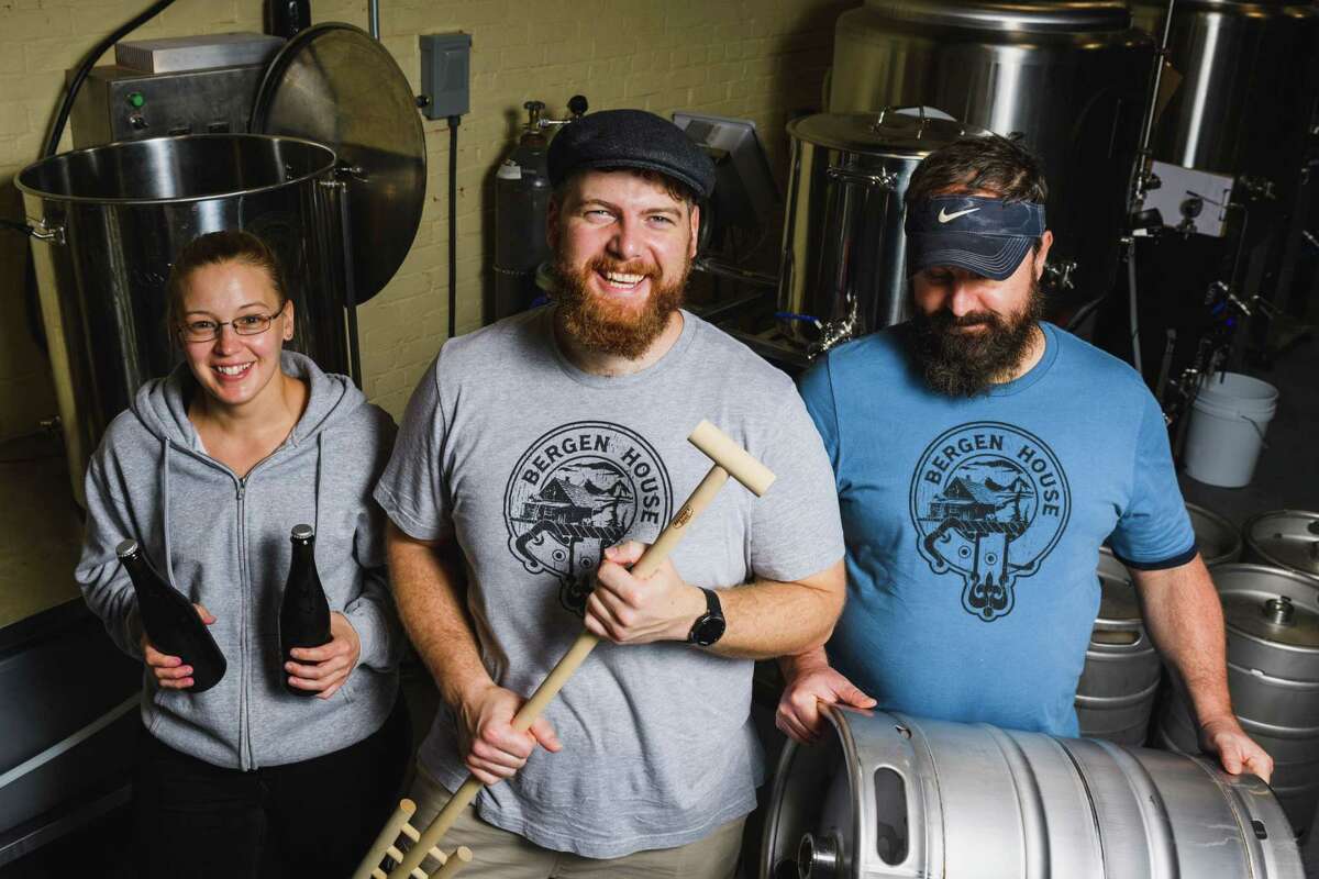 Talon Bergen, center, owner of the Bergen House, a meadery and taproom in Middletown's old trolley barn on King's Avenue, said he wants his business to enrich the community. At left is his wife Emilie, and far right, bartender Tod Davis.