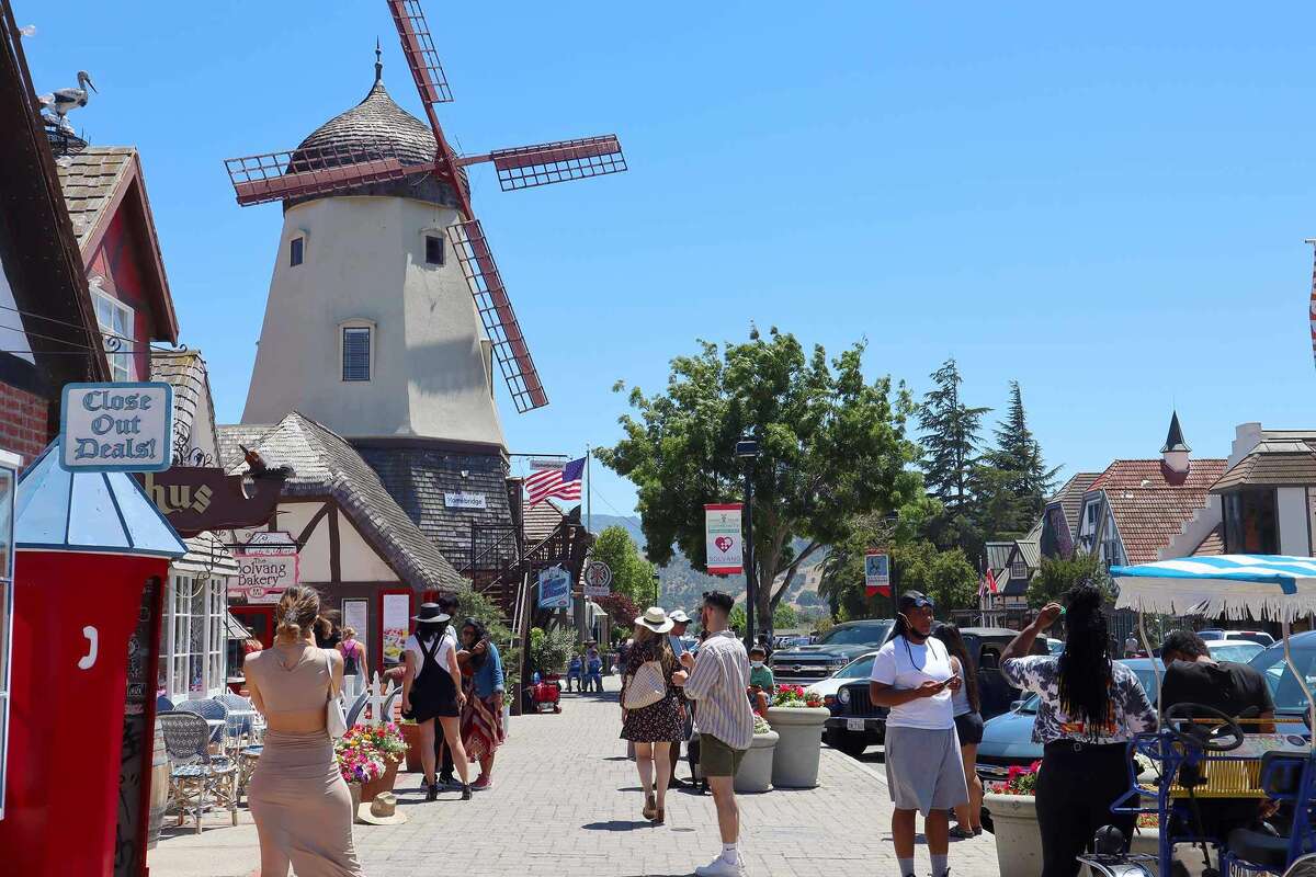 Tourists take photos of a windmill in Solvang, CA on June 26, 2021