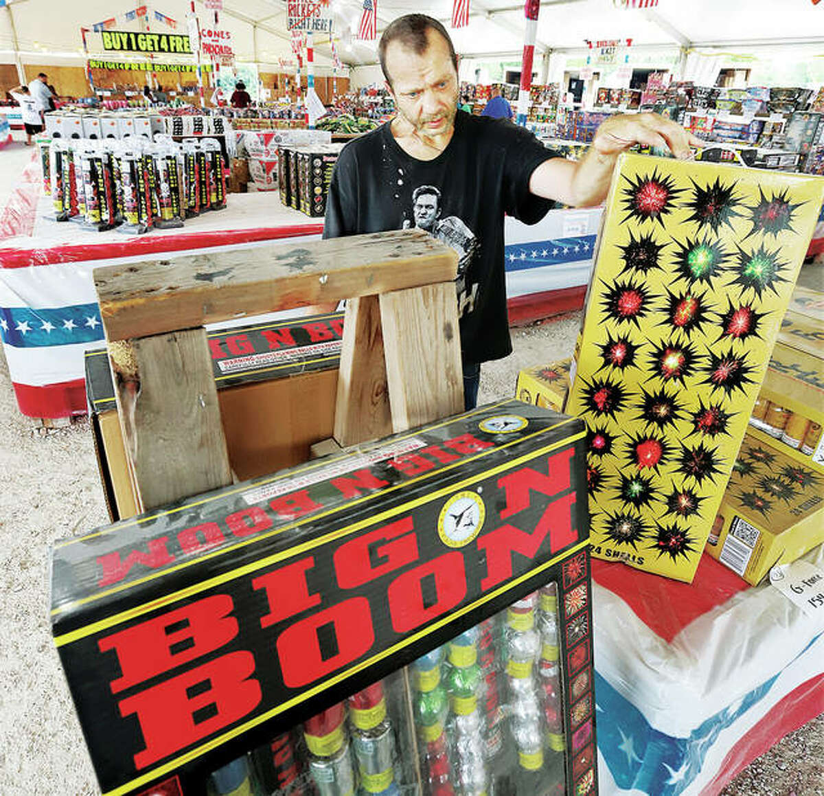 Jason Williams of Kampsville ponders the many fireworks choices Tuesday in the large fireworks tent in West Alton, Missouri where sales were steady.