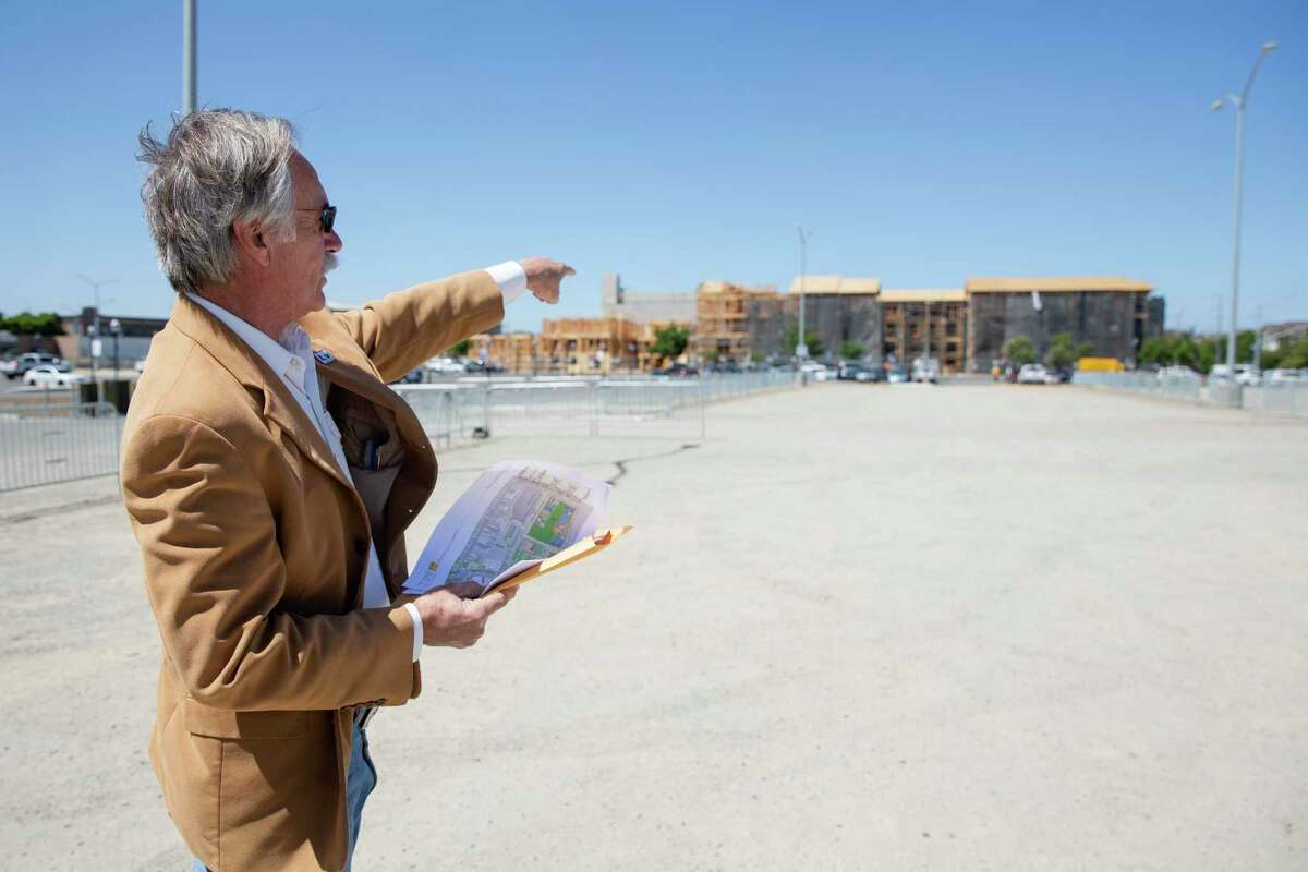 John Marchand, a former mayor of Livermore, points towards the current construction of 220 new market rate apartments behind Stockmen’s Park in Livermore, Calif. The development has been the subject of community strife.