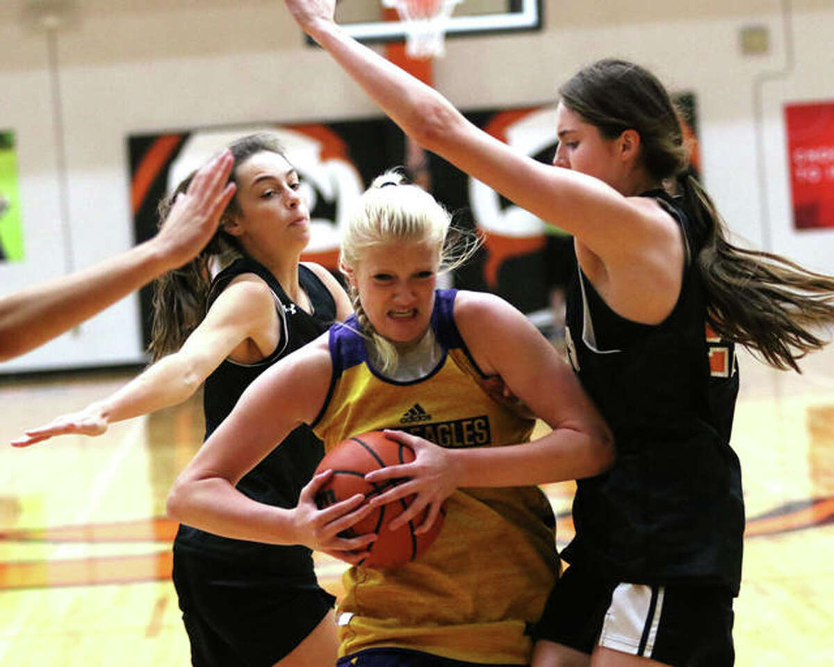 CM’s Claire Christeson (middle) drives to the basket between Edwardsville’s Elle Evans (right) and Kaitlyn Morningstar before falling to the court with a torn ACL in a summer shootout girls basketball game Tuesday at Lucco-Jackson Gym in Edwardsville.