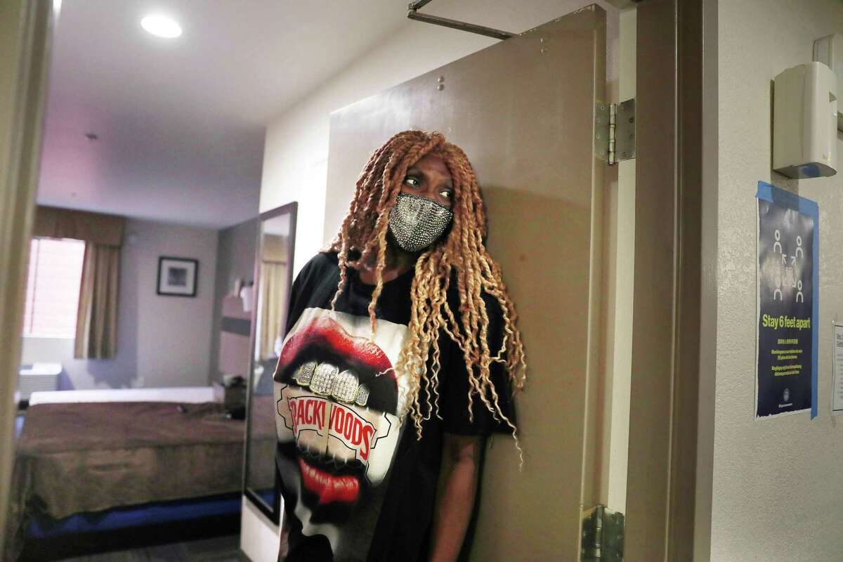 Taijah Minnifield waits at her front door for the delivery of her evening meal in her shelter-in-place hotel room in San Francisco.