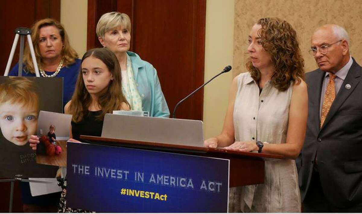 Lindsey Rogers-Seitz, at microphone, and her daughter, Riley, on Capitol Hill in Washington, D.C., for a press conference to promote a federal transportation safety bill called the Invest in America Act, Thursday July 1, 2021.