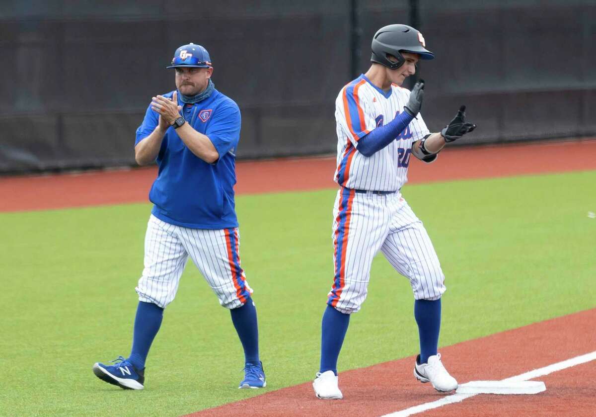 Grand Oaks head coach Lou Ferrell claps alongside AJ McCrady #20 after McCrady was able to advance from first to third after a Tomball pitcher failed to out him during the third inning of a Region II-6A area round series at Grand Oaks High School on Thursday, May 13, 2021, in Spring.