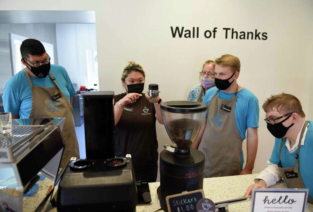 From left, employee Brian Paez, shift lead Maggie Lam, Abilis jo coach Suzanne Ford, employee Spencer Connolley, and employee David Mott make an espresso drink at Coffee for Good in Greenwich, Conn. Wednesday, June 30, 2021. Located on the campus of Second Congregational Church, Coffee for Good employs 24 people with disabilities, training them for permanent employment at other nearby businesses in the community.