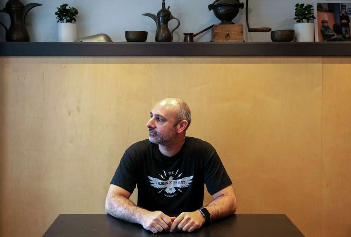 Owner Hrag Kalebjian sits inside Henry’s House of Coffee in San Francisco. Kalebjian has his staff wear masks while at work because of the confusion caused by Cal/OSHA’s issuing of workplace safety rules.