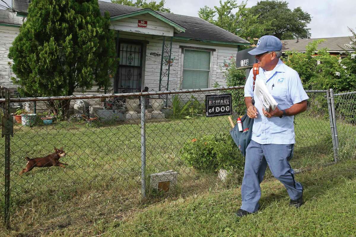 Postal worker Joe Valadez takes care of his route, walking along North Center Street on the East Side.