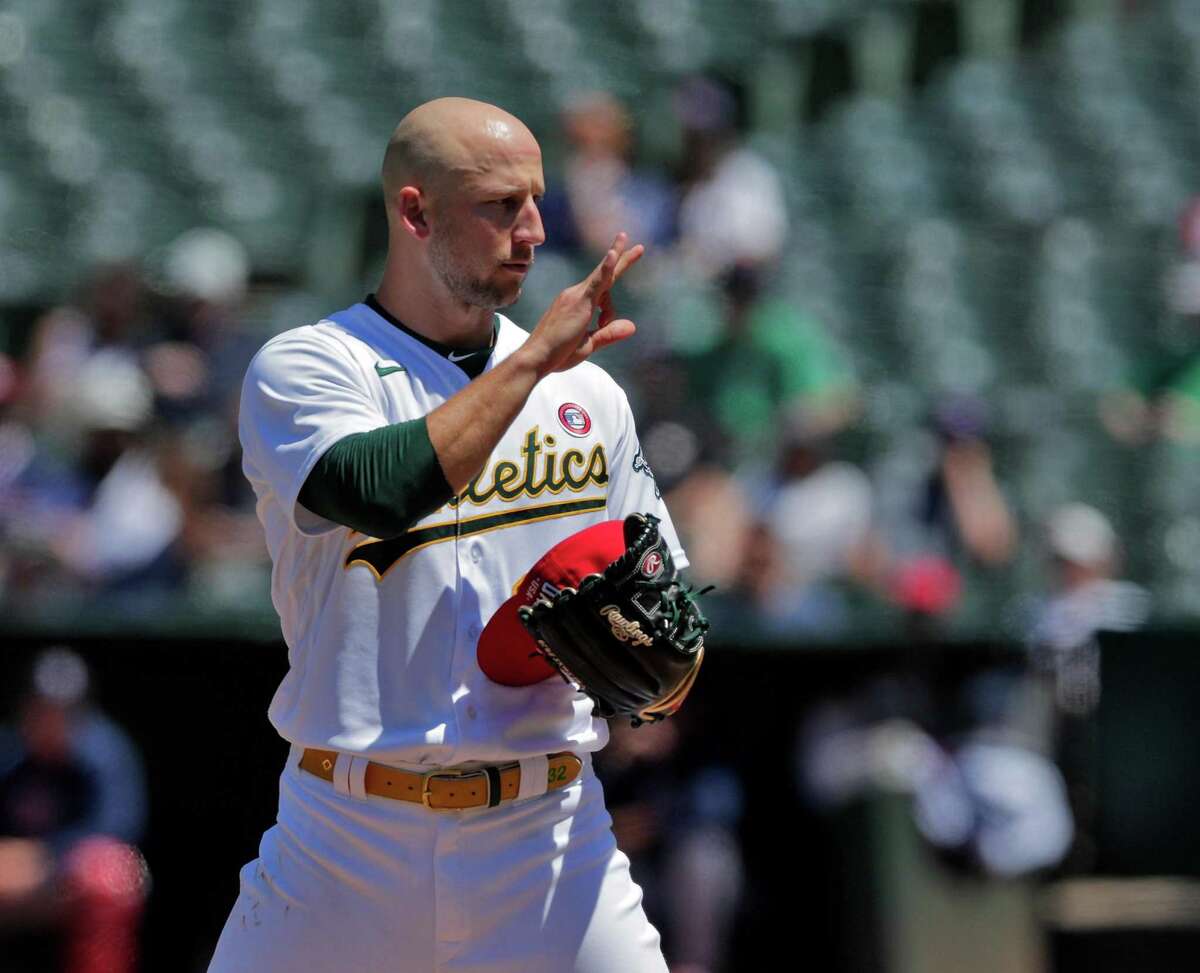 Oakland starter James Kaprielian (32) checks signal swith catcher Aramis Garcia (37) as the Oakland Athletics played the Boston Red Sox at the Coliseum in Oakland, Calif., on Sunday, July 4, 2021.