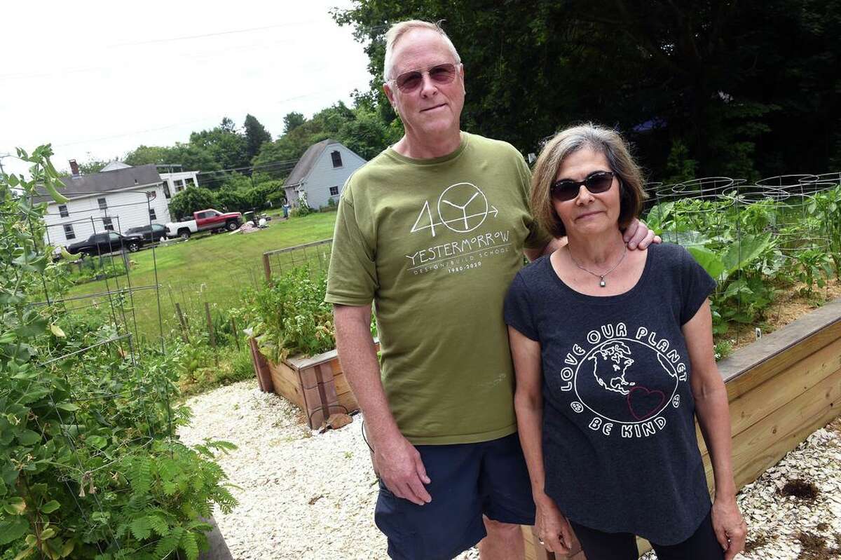 Bill Freeman and his wife, Alicia Dolce, are photographed in the front yard of their home in Guilford next to the property (left) of Eunice Demond of Little Rascals Rescue and Rehabilitation on July 1, 2021, where Demond is seeking a special use permit for her animal rescue operation.