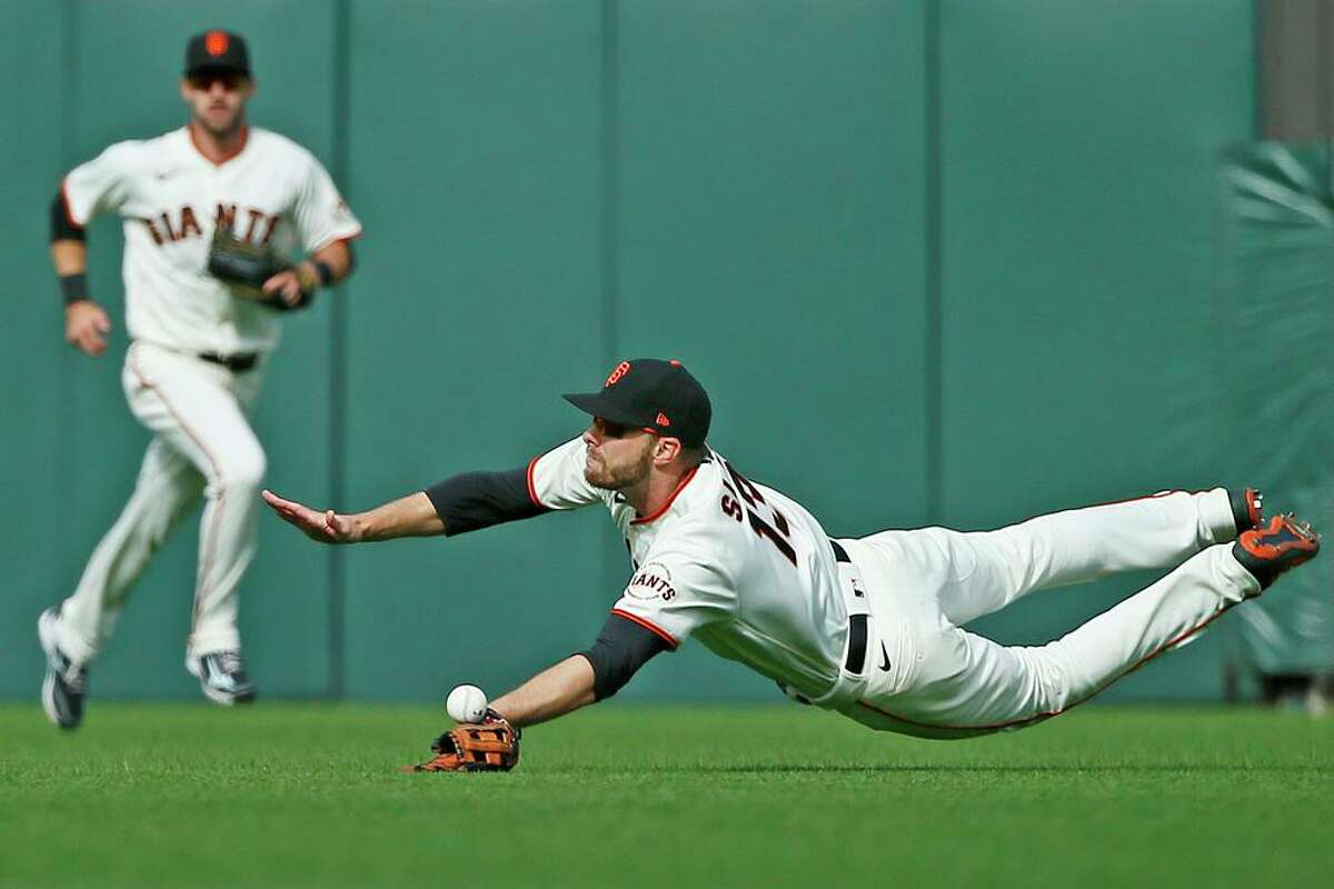 San Francisco Giants right fielder Austin Slater (13) misses the catch on a dive in the eighth inning during an MLB game against the St. Louis Cardinals at Oracle Park, Monday, July 5, 2021, in San Francisco, Calif.