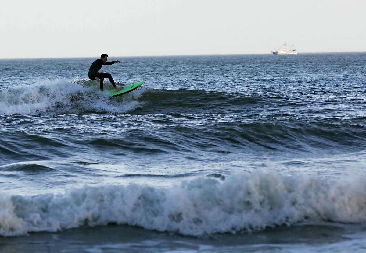 A surfer at Galveston Beach during spring break on Wednesday, March 17, 2021.