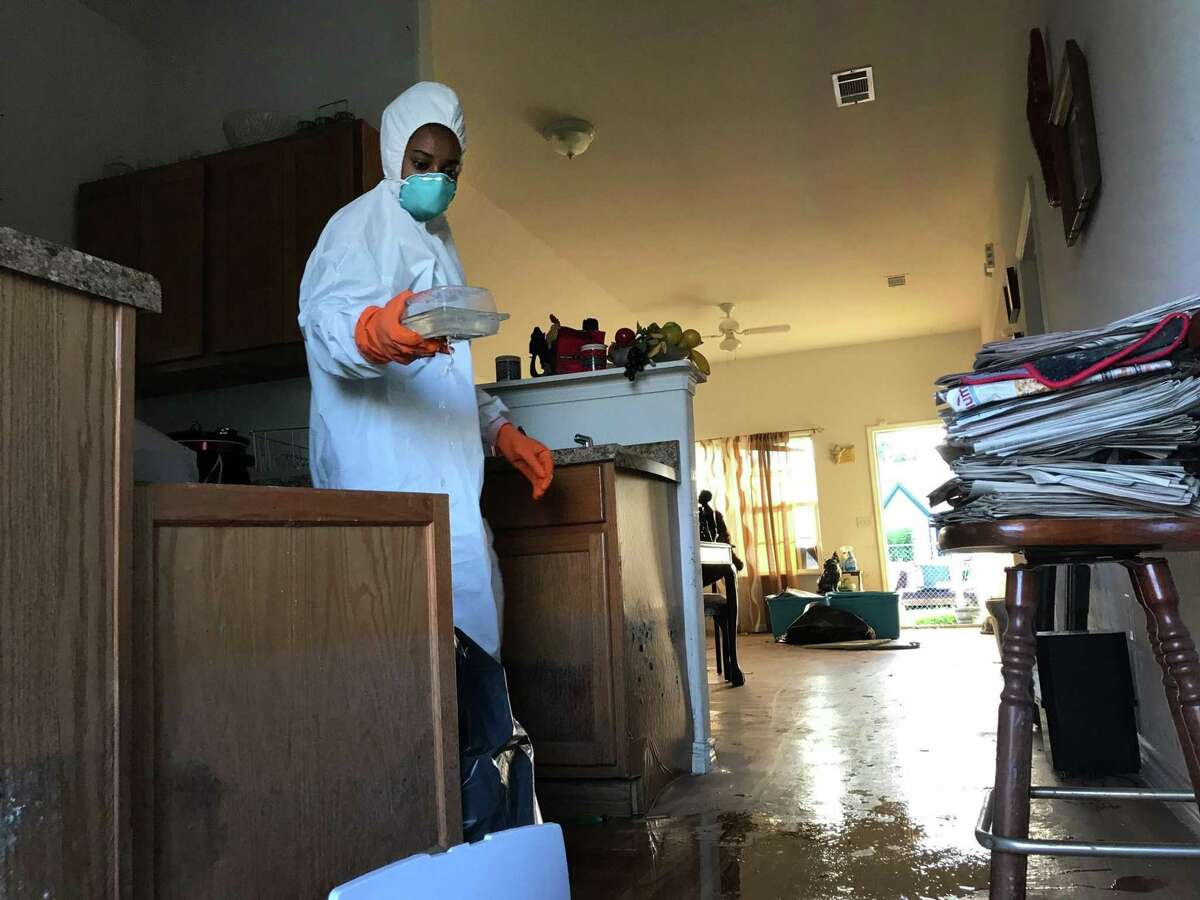 Corinth Williams, 28, discards kitchenware as she helps clean out her grandmother's house in Port Arthur. The city was flooded after Hurricane Harvey unleashed torrential rains and left houses filled with moldy furniture and personal items. (David Montero/Los Angeles Times/TNS)