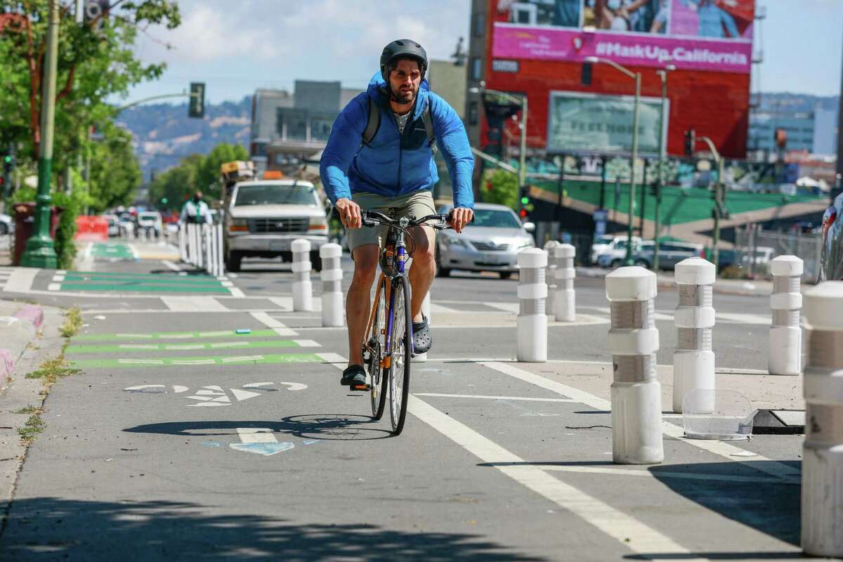 A cyclist rides in the bike lane on Telegraph Avenue on Wednesday, June 9, 2021 in Oakland, California.The Oakland Department of Transportation wants the city council to remove protected bike lanes on a nine-block downtown corridor on Telegraph Avenue later this year after installing them in 2016. The Oakland Department of Transportation director says the protected lanes from 20th to 29th Streets simply are not working.