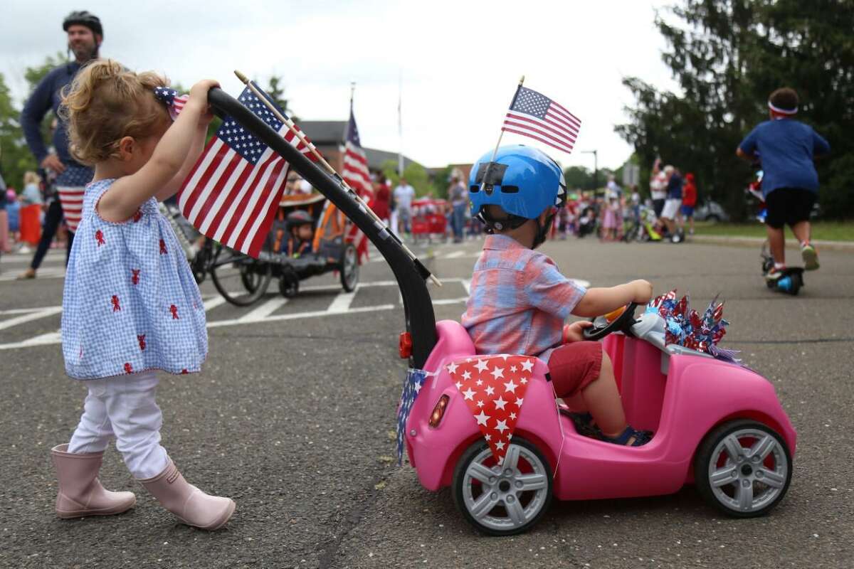 Parker Farris, 2, left, practices parading with Peyton Mathis, 2, at the Pull-N-Pull Parade at Darien High School on Sunday, July 4, 2021.