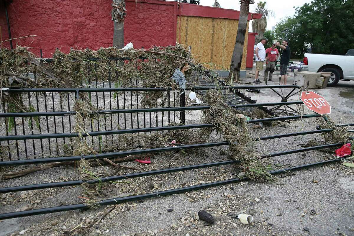 Logan Rhodes (from right), Sal Ramos and Nate Brown stand near damaged gates and debris at the Comfort Cafe located at 5618 Bandera Road after a catastrophic flood from the heavy rainstorms pounded parts of the city on Tuesday, July 6, 2021. The cafe owners support the addiction recovery program, Serenity Star, where some of the program's peers help run the restaurant. Their restaurant is a nonprofit - everyone who works here is in recovery and volunteer their services. They ask customers who come here to eat to pay a suggested $10 donation or whatever they can afford. The restaurant is totaled - they estimate the flood waters reached 4 and a half feet high. Wet mud is covering everything.