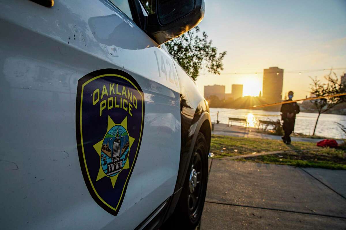 An Oakland police car near Lake Merritt. An Oakland man was arrested Wednesday after allegedly crashing his vehicle into another car and killing two of the three passengers inside, police said.