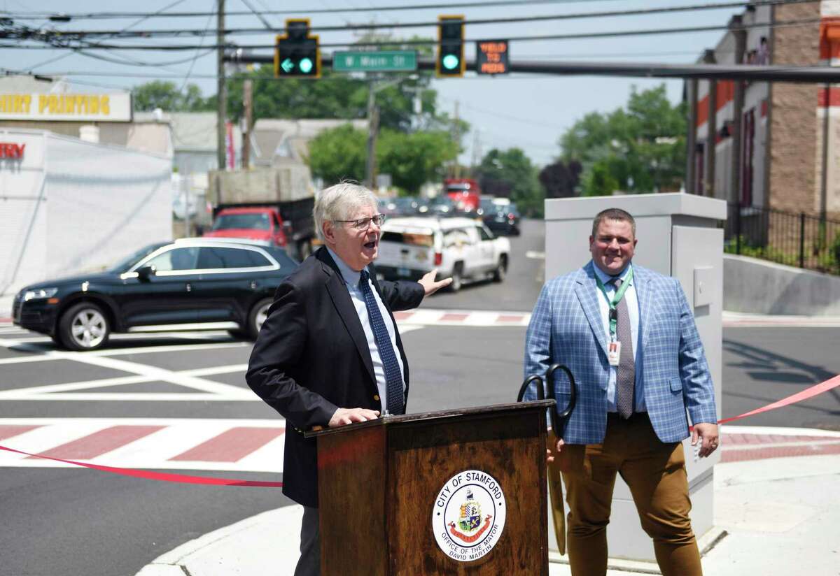 Stamford Mayor David Martin, left, and Stamford Transportation, Traffic & Parking Interim Bureau Chief Frank Petise speak at the ribbon-cutting for the new and improved intersection of West Avenue and West Main Street in Stamford on Wednesday.