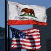 The California State flag flies beside a sign for its sister city Split outside City Hall, in Los Angeles. Despite ongoing claims about an “exodus” of people moving out of California, another survey suggests the claims aren’t accurate.