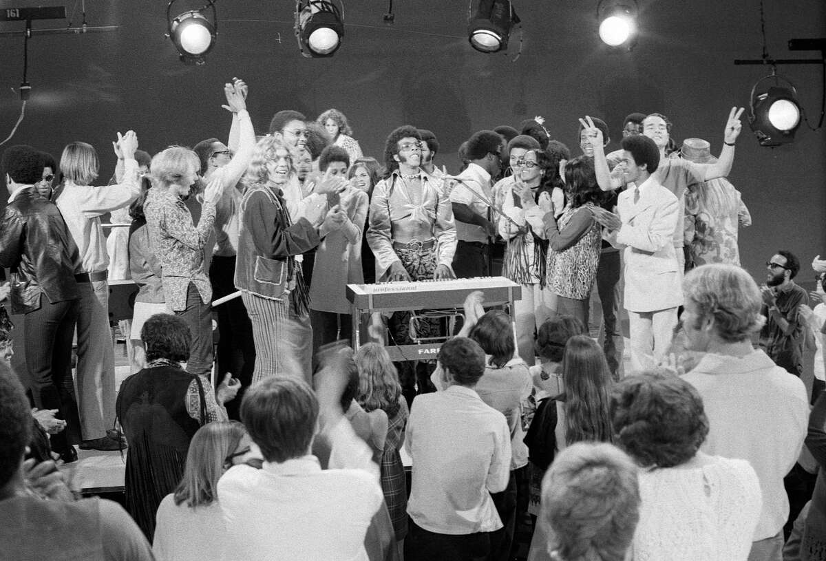 The audience joined Sly and the Family Stone on stage on television on October 15, 1969. Sly Stone is in the center with glasses.