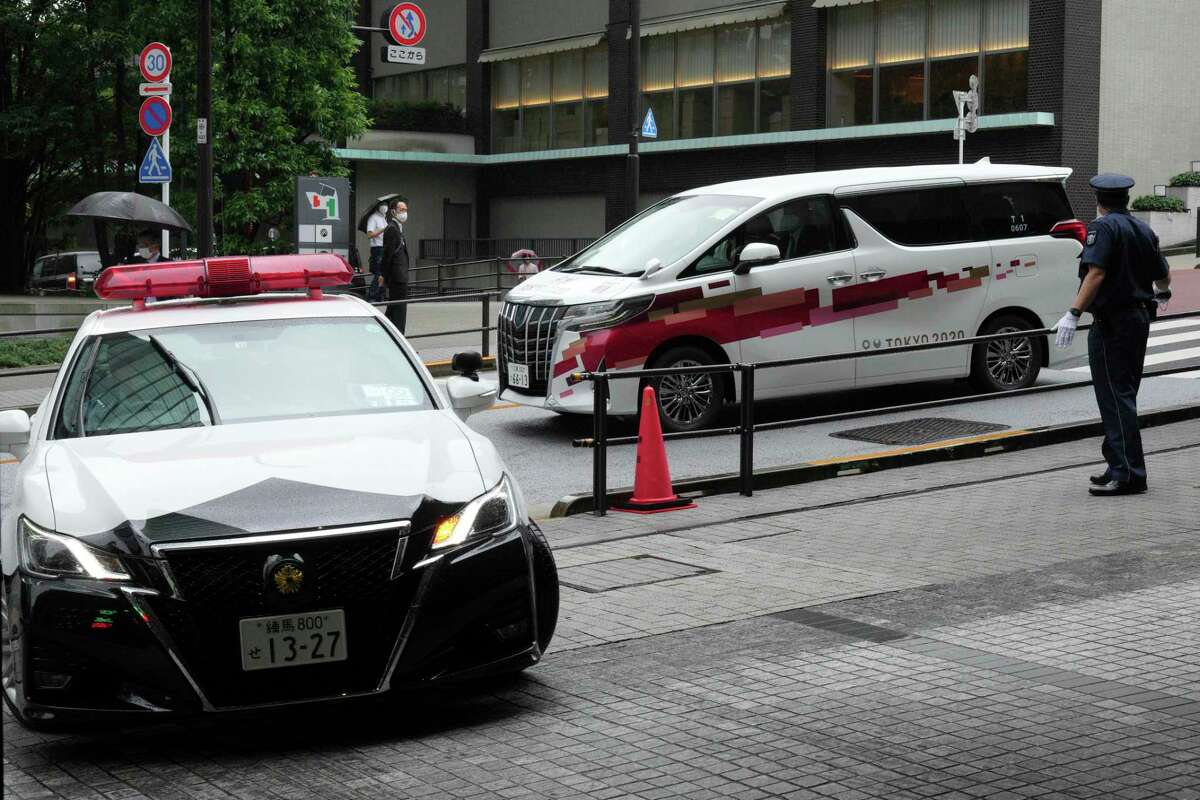 A vehicle, right, which International Olympic Committee (IOC) President Thomas Bach is boarding, is escorted to an accommodation Thursday, July 8, 2021, in Tokyo. Bach arrived on Thursday, July 8, 2021, in Tokyo as Japan Prime Minister Yoshihde Suga was set to declare a state of emergency that is likely to result in a ban on fans from the Tokyo Olympics as coronavirus infections spread across the capital.