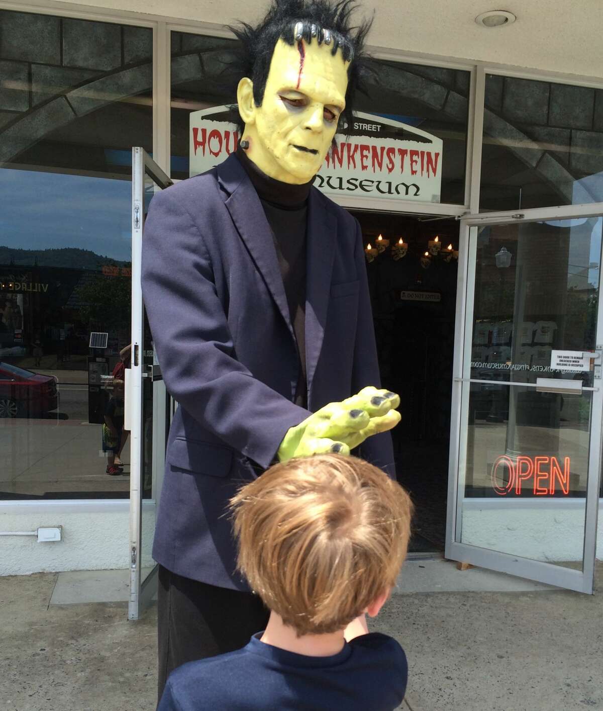 Frankenstein gives a high-five to a boy outside of the House of Frankenstein Wax Museum in Lake George. This year's worker shortage means that Frankenstein does not man the door at the Lake George attraction.