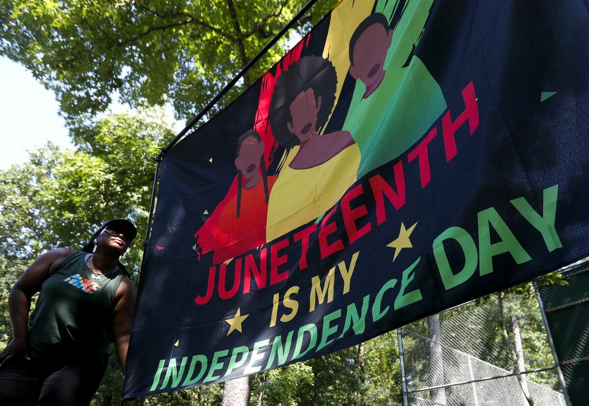 Tasia Payne hangs a Juneteenth flag during a Juneteenth celebration at Kasmiersky Park, Saturday, June 19, 2021, in Conroe. Juneteenth, which recently became a federal holiday after being signed into law this week by President Joe Biden, recognizes the end of slavery in the United States. It is held on June 19, the anniversary of the announcement of emancipation for enslaved people in Texas in 1865, nearly three years after President Abraham Lincoln signed the Emancipation Proclamation.
