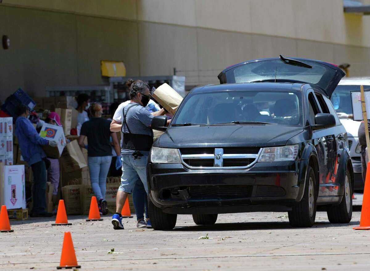 Workers at the San Antonio Food Bank load cars during a food distribution last summer. As the community emerges from the pandemic, the city make its burgeoning workforce program innovative.