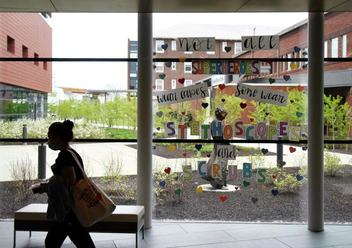 A hospital employee walks past a note of positivity on the window at Stamford Hospital in 2020. With COVID-19 cases way down, patients can again have visitors.
