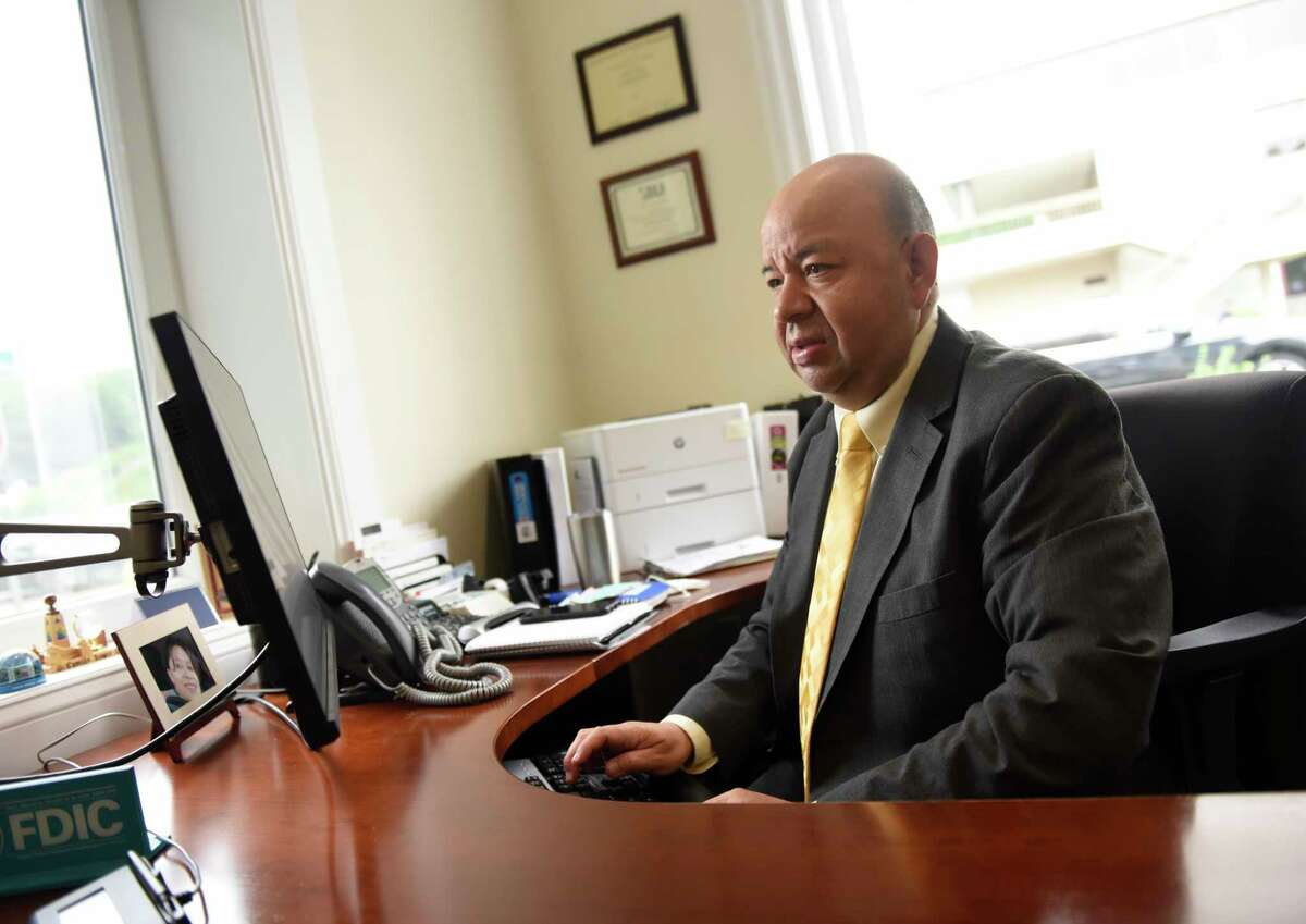 Branch Manager Camilo Duque Jr. works in his office at First County Bank in Stamford, Conn. Thursday, July 8, 2021.