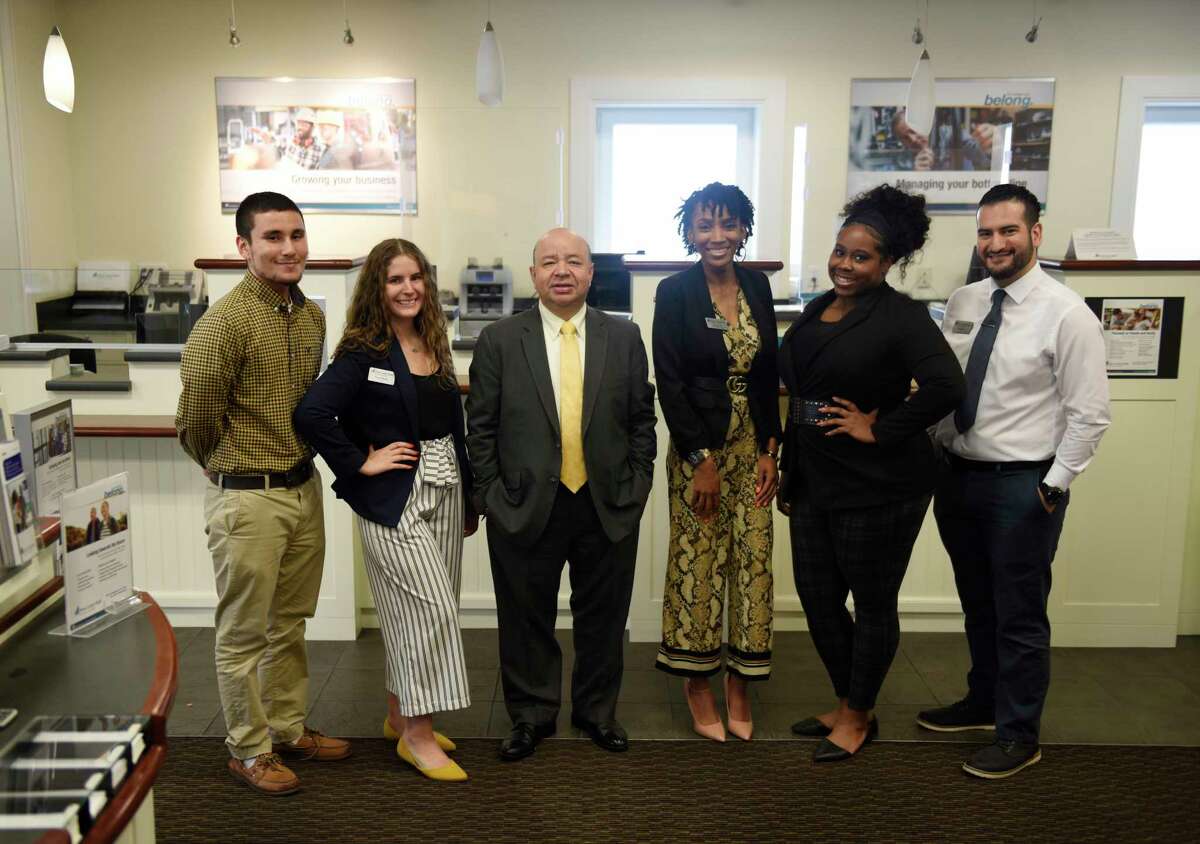 Branch Manager Camilo Duque Jr., third from left, and Assistant Branch Manager Monique Gist, fourth from left, pose with members of their team at First County Bank in Stamford, Conn. Thursday, July 8, 2021.