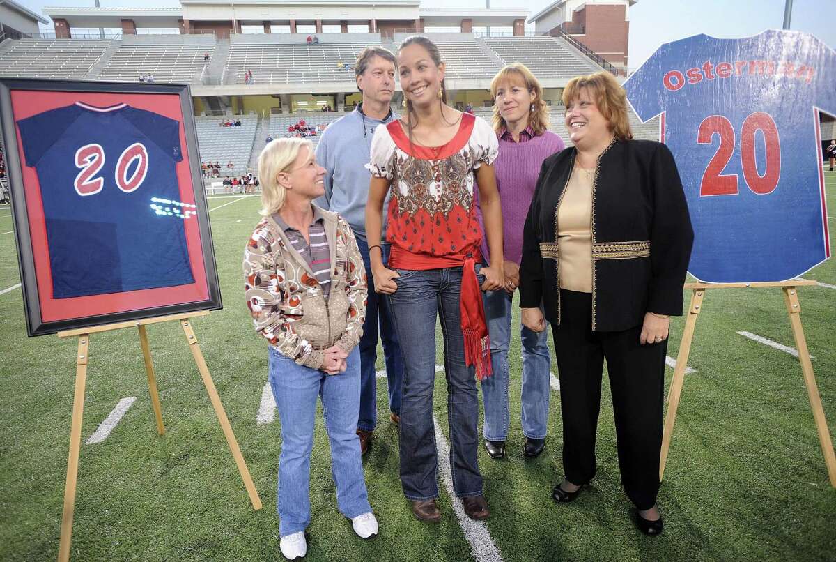 In 2008, Cat Osterman, center, shares her special moment with her former Cy-Springs' softball coach Carol Adcock, left, parents Gary and Laura Osterman, and school principal Barbara Weiman during the ceremony before the game between Langham Creek Lobos and Cypress Springs Panthers.
