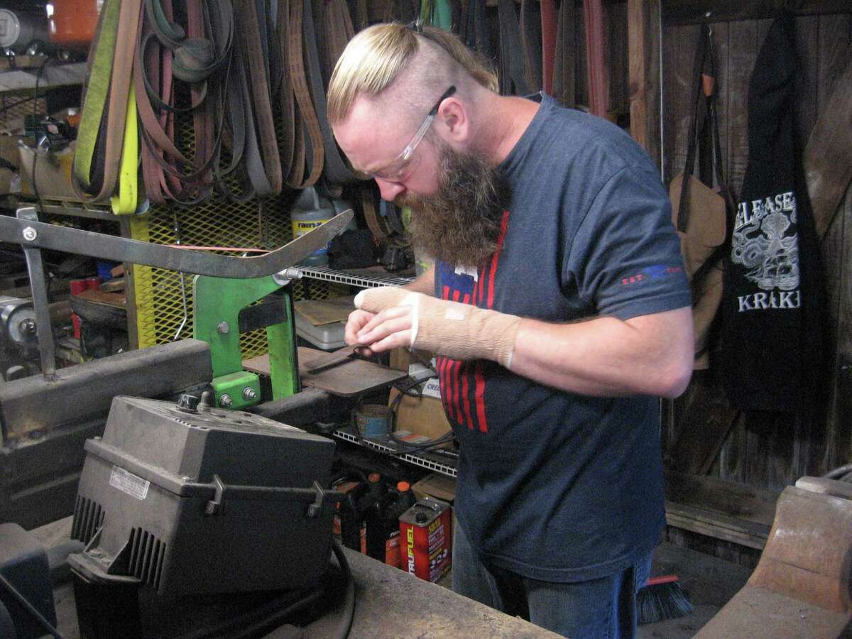 Jerrod Sutcliffe works in his forge in Torrington. Sutcliffe, a Navy veteran, says his work helps with the mental and physical effects of his time fighting in Iraq.