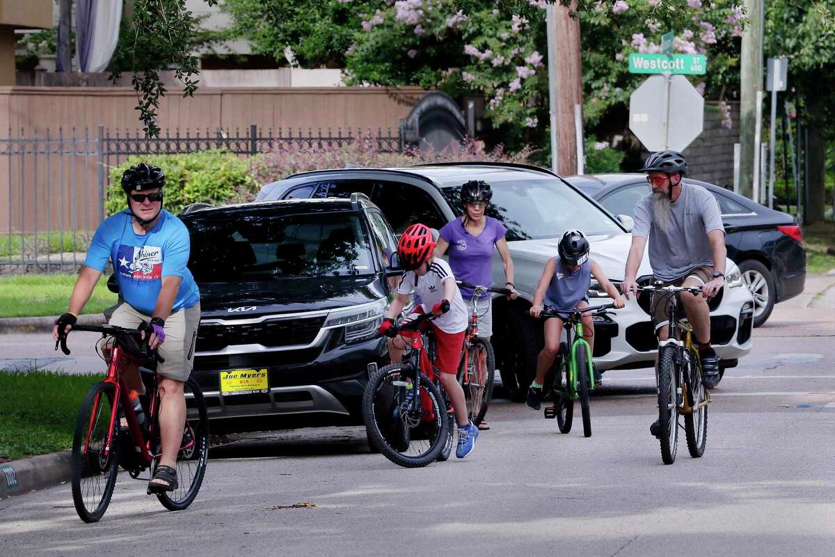 Adults and children on bikes negotiate breaks in traffic as they cross Westcott on Blossom near Memorial Park on July 7, 2021. Memorial Park is seeing improvements, but the access areas around the park for those who use it have not seen many improvements.